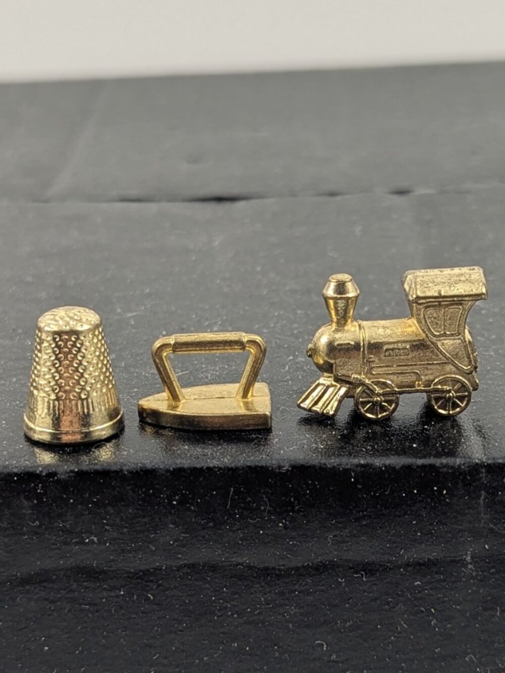 Three gold color monopoly replacement pieces train, thimble, iron